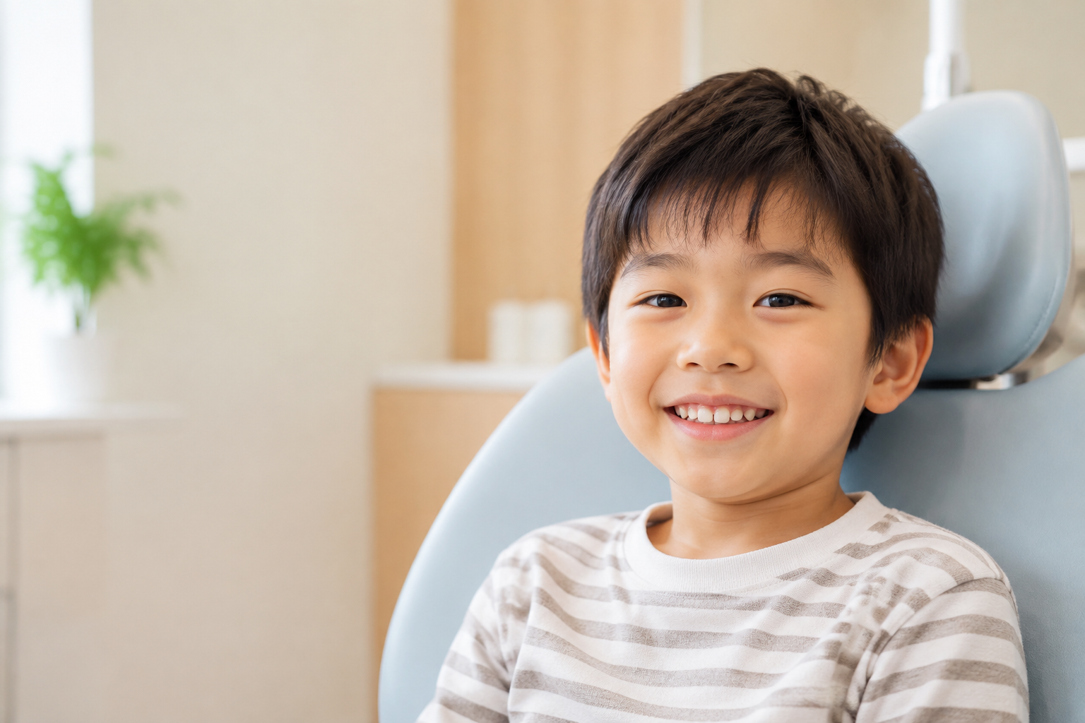 歯科診療に安心して歯を見せながら笑う男の子のイメージ