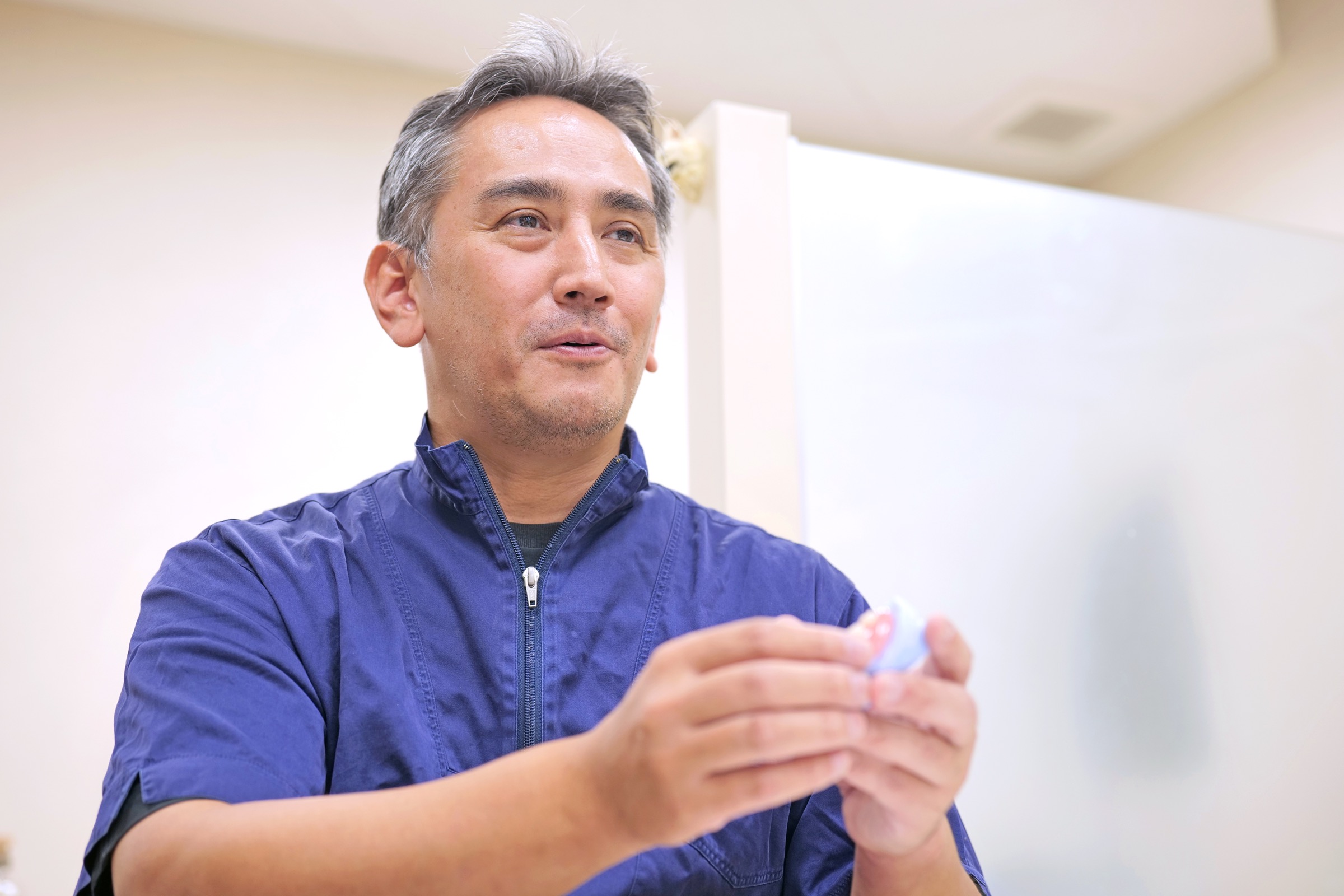 入れ歯を手に治療の選択肢を説明する院長