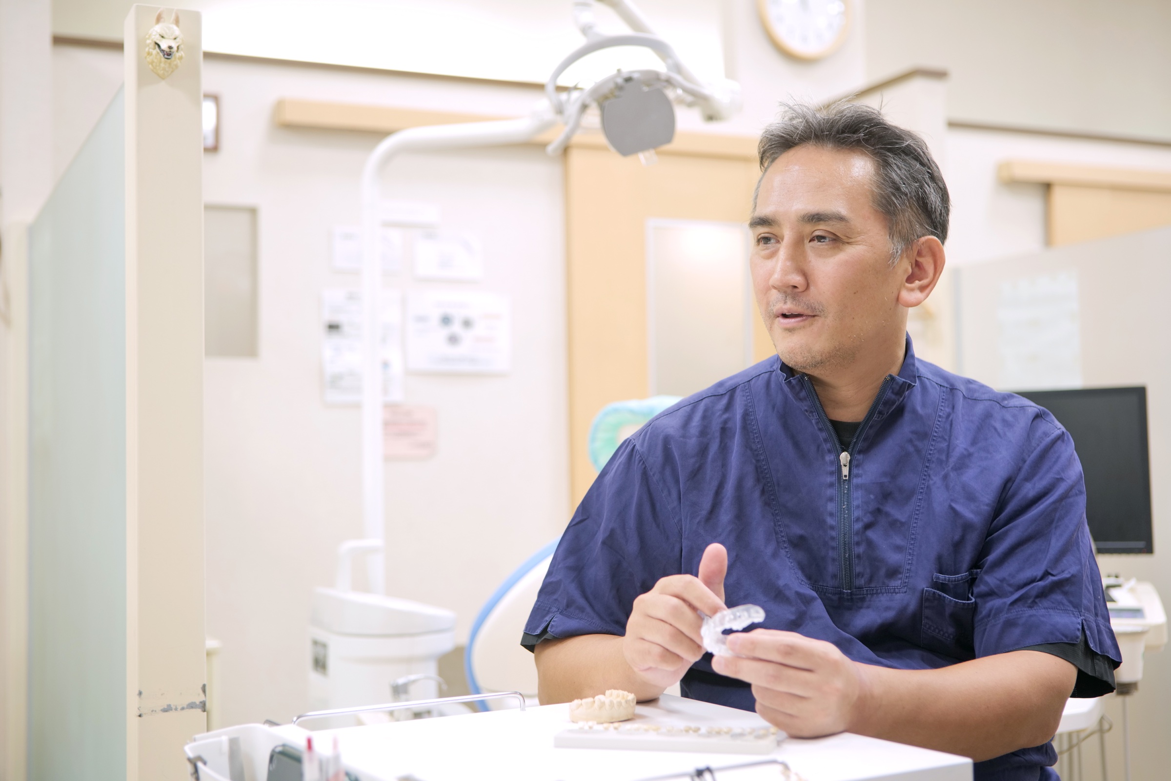 ホワイトニング用マウスピースを手に説明する院長