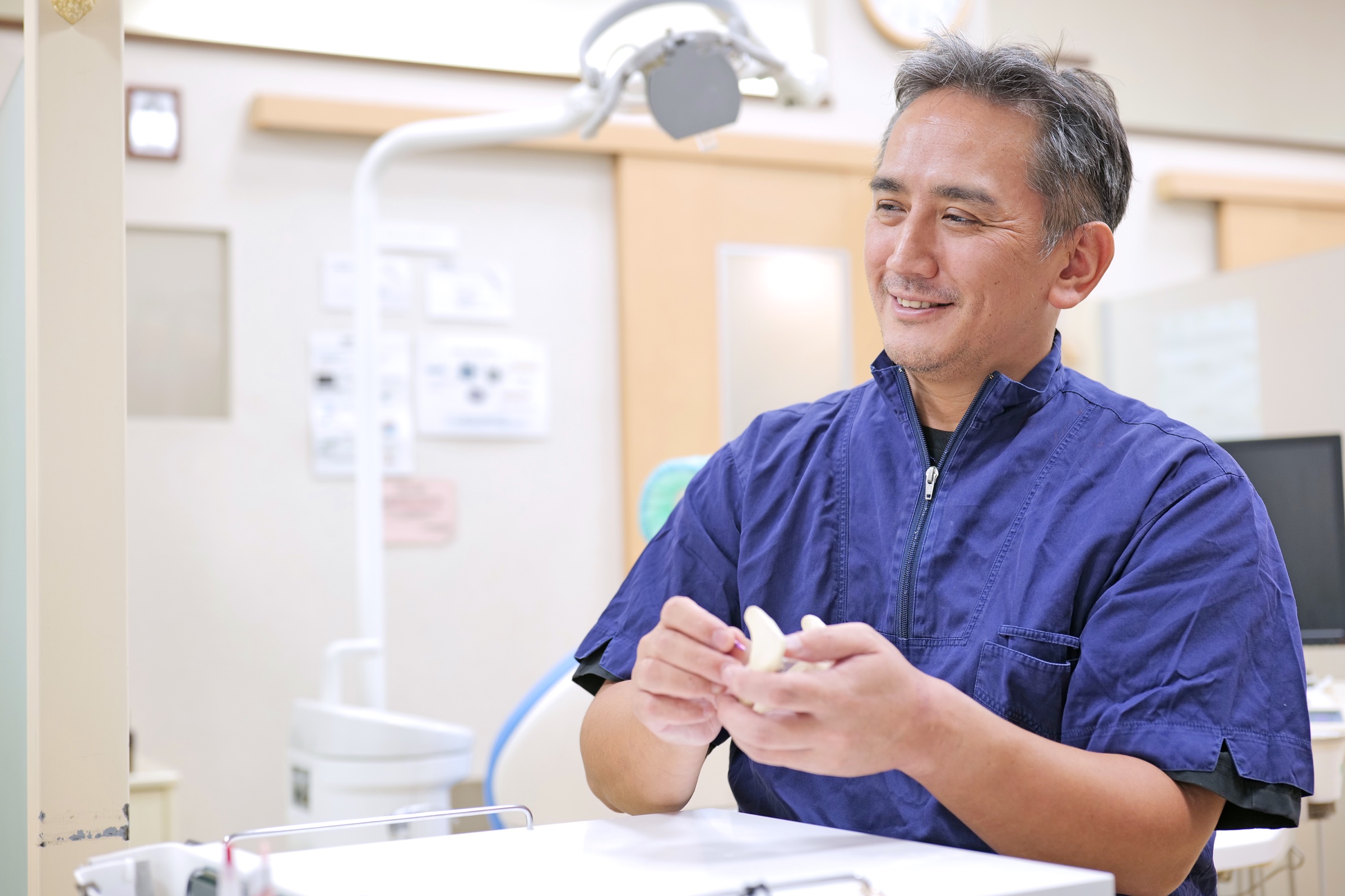院長が模型を手にインプラント治療について説明する様子