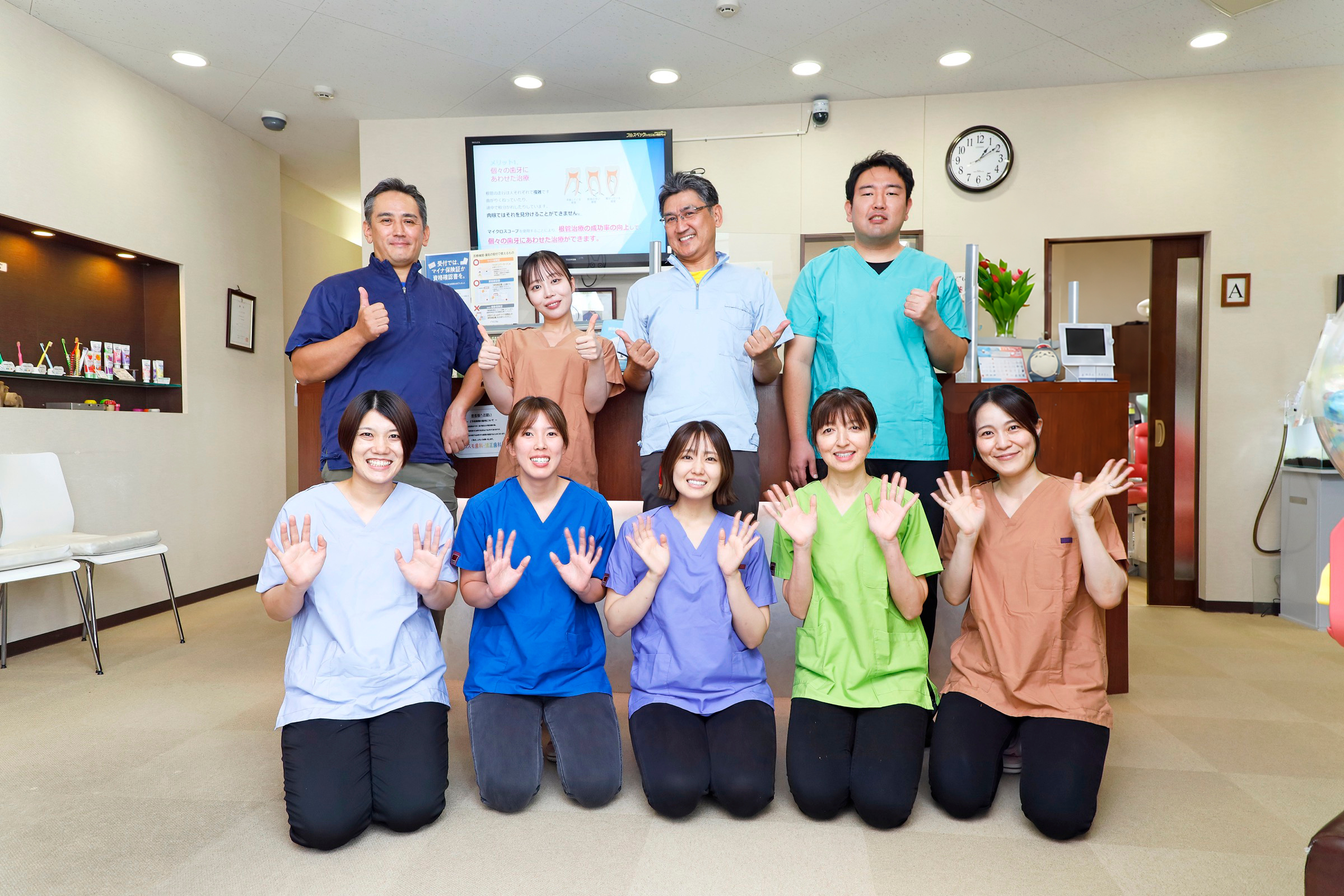手を振るコスモ歯科・矯正歯科医院のスタッフ集合写真